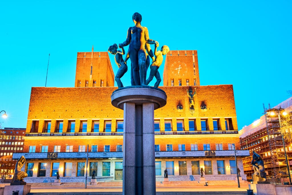 Statue fountain before Oslo City Hall at dusk