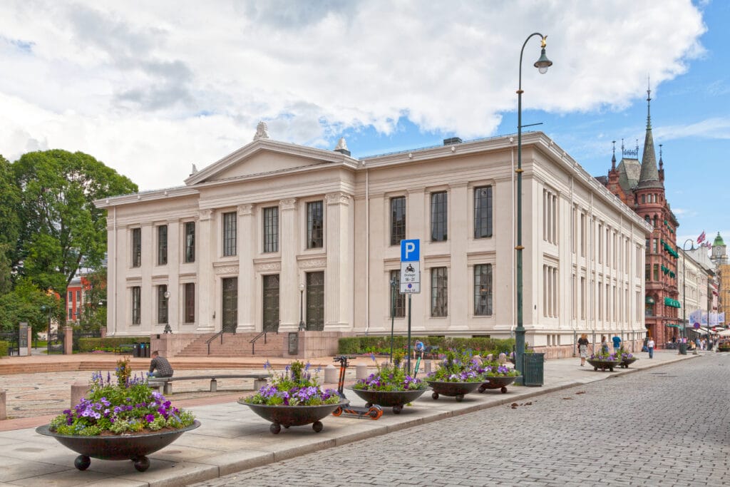 Neoclassical building along cobbled street with flower planters