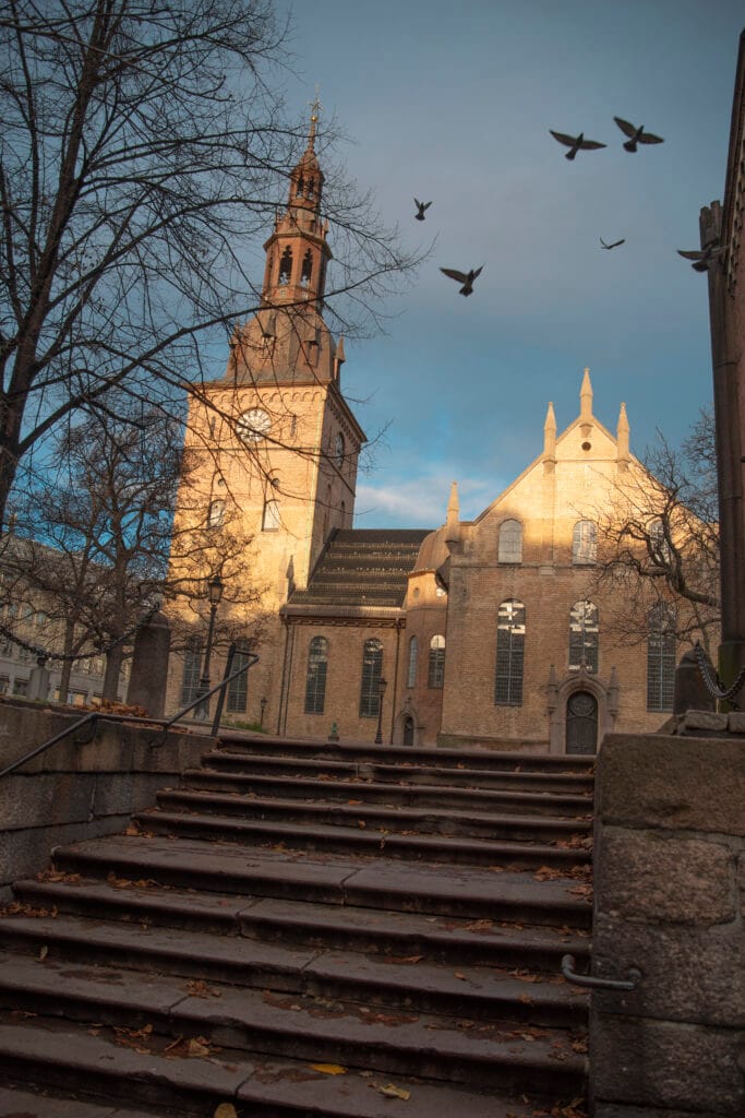 Historic brick church with clock tower at sunset
