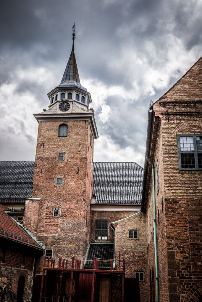 Historic brick clock tower under cloudy sky
