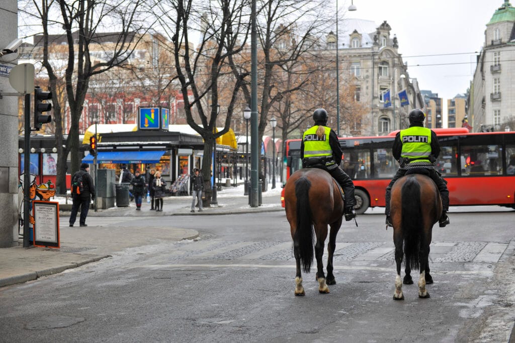 Mounted police officers patrolling city street junction